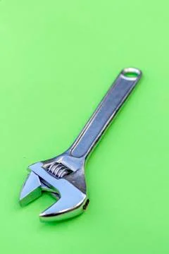 Adjustable wrench on green background Stock Photos