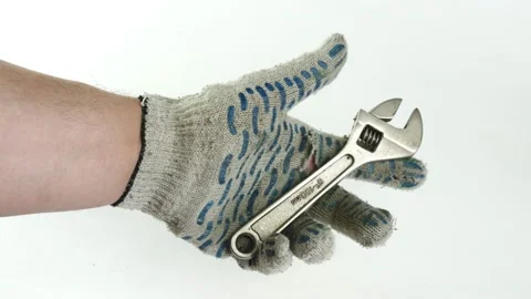 Adjustable wrench in the hands of a man. Man with the construction dirty gloves. Stock Footage 143014236