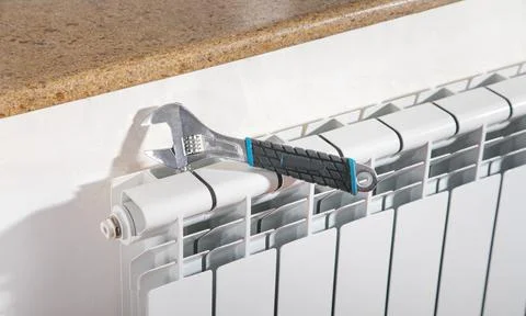 Adjustable wrench on the heating radiator. Stock Photos