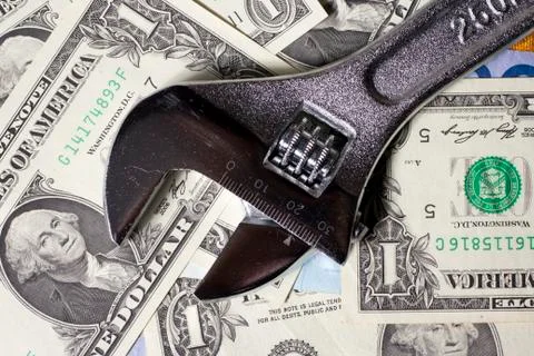 Adjustable wrench on US dollar banknotes Stock Photos