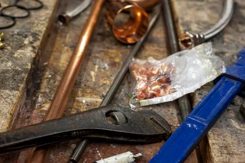 Adjustable wrenches on a cluttered old workbench Stock Photos