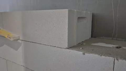 Adjusting aerated concrete block wall slow motion front view Stock Footage 335298803