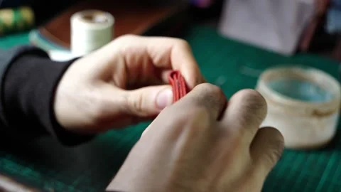 Adjusting and Pressing Red Leather Wallet Edges with Wet Glue by Hand Stock Footage 314961892