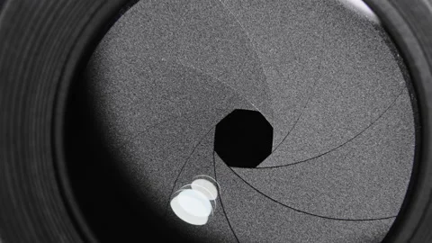Adjusting aperture on camera lens. Close up view. Iris blades open and close Stock Footage 130752625