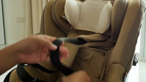 Adjusting Black Strap on Beige Car Seat in Sunlit Interior Video stock 337140412