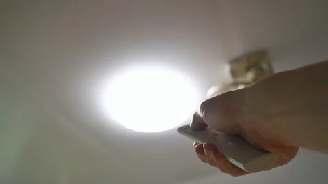 Adjusting the brightness level of the ceiling light by remote control Video stock 164904874