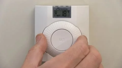 Adjusting a central heating thermostat Stock Footage 12352453