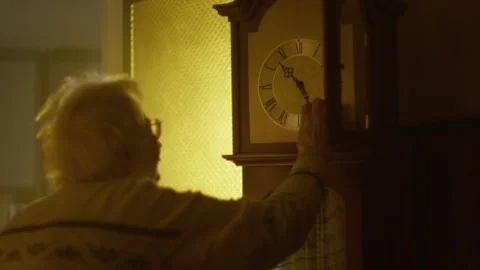 Adjusting a classic clock pendulum in a cozy apartment space Stock Footage 319926481