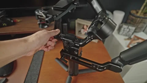 Adjusting DJI RS 5 Micro Knobs on Modern Office Desk Stock-Footage 332709400