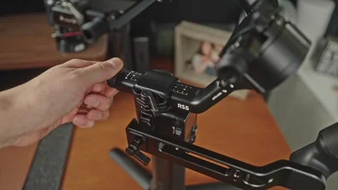 Adjusting DJI RS 5 Micro Knobs on Modern Office Desk medium tight shot Stock-Footage 332710677