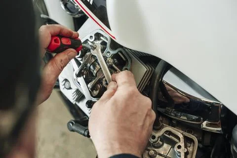Adjusting engine valves of motorcycle at the workshop Stock Photos