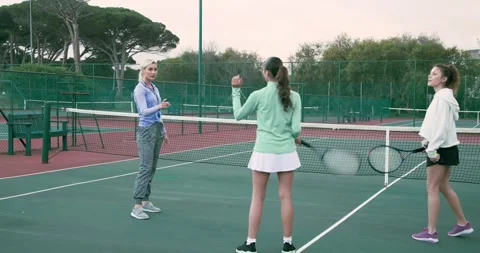 Adjusting grip, coach and students practicing racket swings celebrating on Stock Footage 343836892