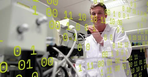 Adjusting lab tech wearing white lab coat at bench with instrument, cables, Foto stock