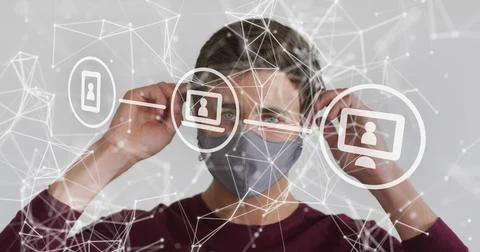 Adjusting man pulling gray mask ear loops against light gray wall, maroon Stock Photos