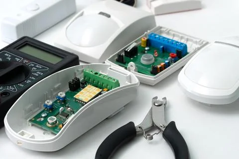 Adjusting motion sensor security systems on white background. Stock Photos