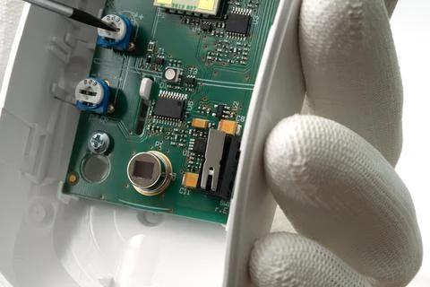 Adjusting motion sensor security systems on white background. Stock Photos