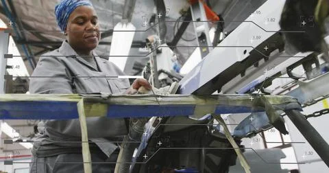 Adjusting operator in gray jacket, blue-scarf at line, using white control panel Stock Photos