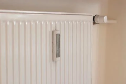 Adjusting the radiator temperature using a thermostat in an apartment Stock Photos