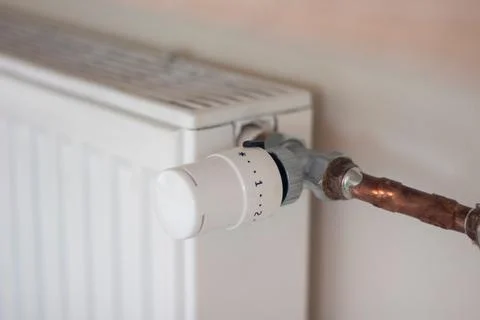 Adjusting the radiator temperature using a thermostat in an apartment Stock Photos