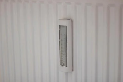 Adjusting the radiator temperature using a thermostat in an apartment Stock Photos