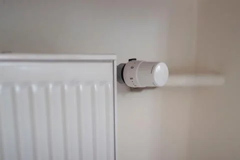 Adjusting the radiator temperature using a thermostat in an apartment Stock Photos