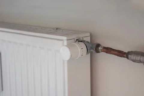 Adjusting the radiator temperature using a thermostat in an apartment Stock Photos