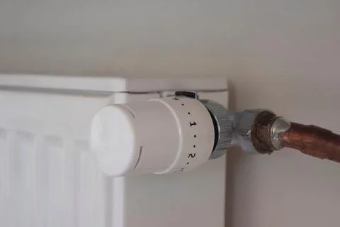 Adjusting the radiator temperature using a thermostat in an apartment Stock Photos