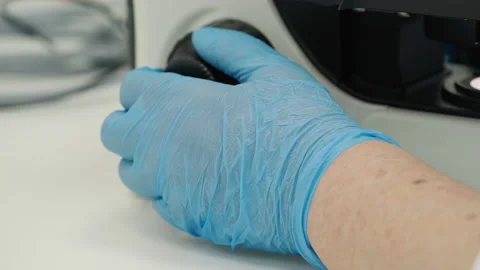 Adjusting the scientific microscope for blood smear biomaterial analysis Stock Footage 218468895