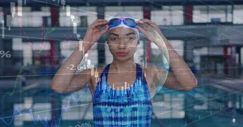 Adjusting swimmer securing goggles at covered pool in blue swimsuit, white cap, Stock Photos