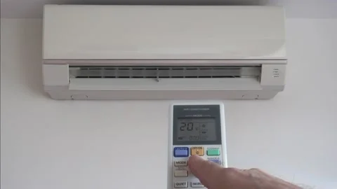 Adjusting temperature air conditioner on remote control in living room Stock Footage 137510338