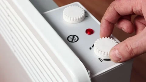 Adjusting temperature on thermostat dial of convector heater. Video stock 235275854