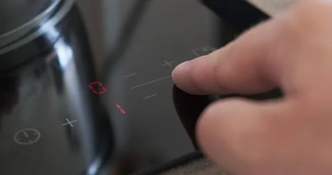 Adjusting temperature on touch panel of induction cooktop by pressing buttons. Stock Footage 149673944