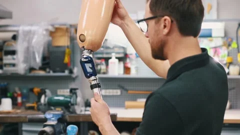 Adjusting tightness of the prosthesis. Technician working in modern laboratory. Stock Footage 243634320