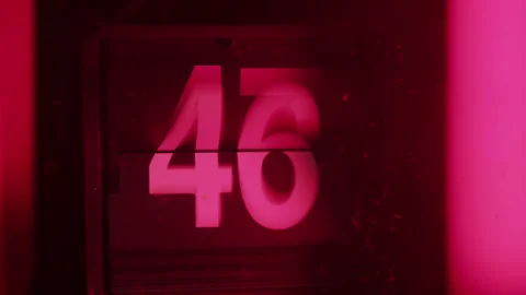 Adjusting a time on a flip clock in red ambient light Stock Footage 315520187