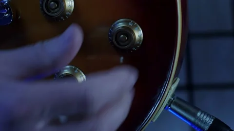 Adjusting tone knobs and volume of electric guitar, close up. Vertical video Stock Footage 239484865