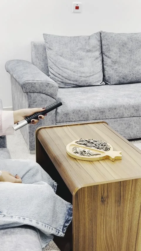 Adjusting TV volume with a remote control, vertical view Stock Footage 345152835