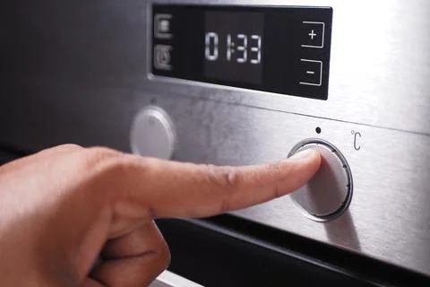 Adjusts temperature on oven for precise baking, providing culinary convenience Stock Photos