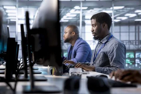 Admin coworkers in data center using PC to check for server performance issues Stock-Fotos