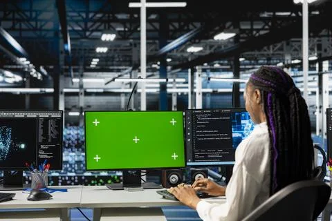 Admin in data center managing AI training datasets using green screen PC Foto stock