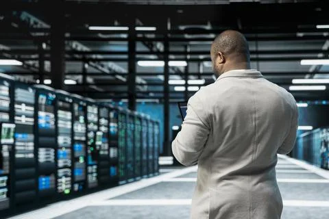 Admin in data center updating systems using tablet, conducting security audits Stock Photos