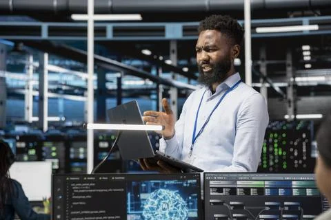 Admin in data center using AI perplexed by glitches affecting equipment 写真素材