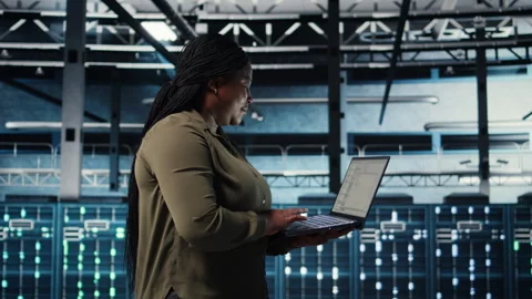 Admin in data center using app on laptop to ensure error free rigs networks Stock Footage 317126341