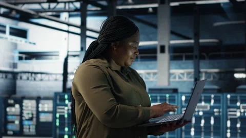 Admin in data center using app on laptop to ensure error free rigs networks Stock Footage 317126378