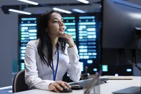 Admin in data center using computer to check for server performance issues Stock Photos