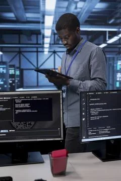 Admin in data center using system monitoring software on tablet device Foto stock