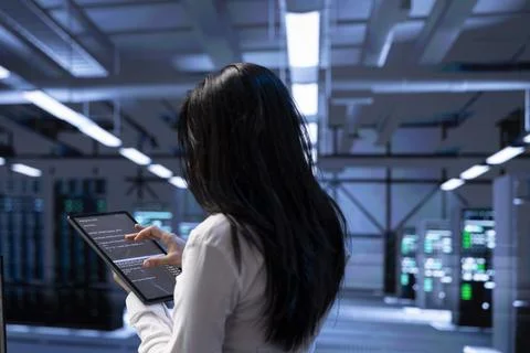 Admin in data center using tablet to check for server performance issues Stock Photos