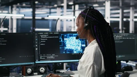 Admin in data center wearing headset assisting users with AI Stock Footage 313636296