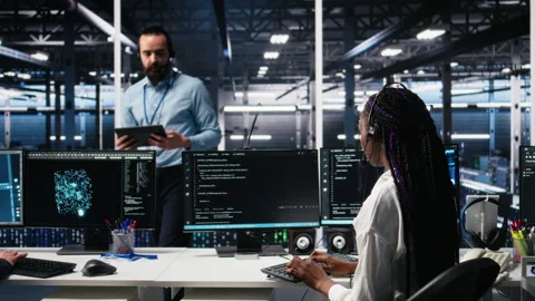 Admin in data center wearing headset assisting users with AI Stock Footage 313637826