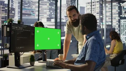 Admin doing software debugging on green screen PC with colleague Foto stock