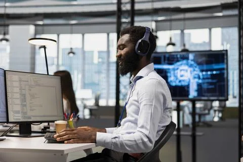 Admin in office using AI automation to do coding tasks, listening music Foto stock
